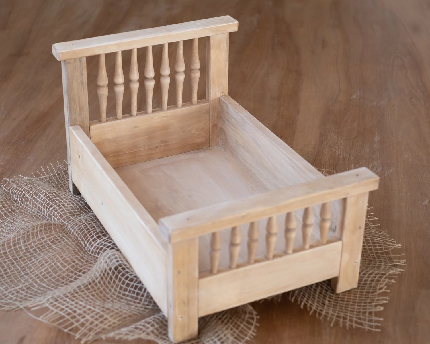 Natúr színű, antikolt fa ágy esztergált díszítéssel újszülött fotózáshoz