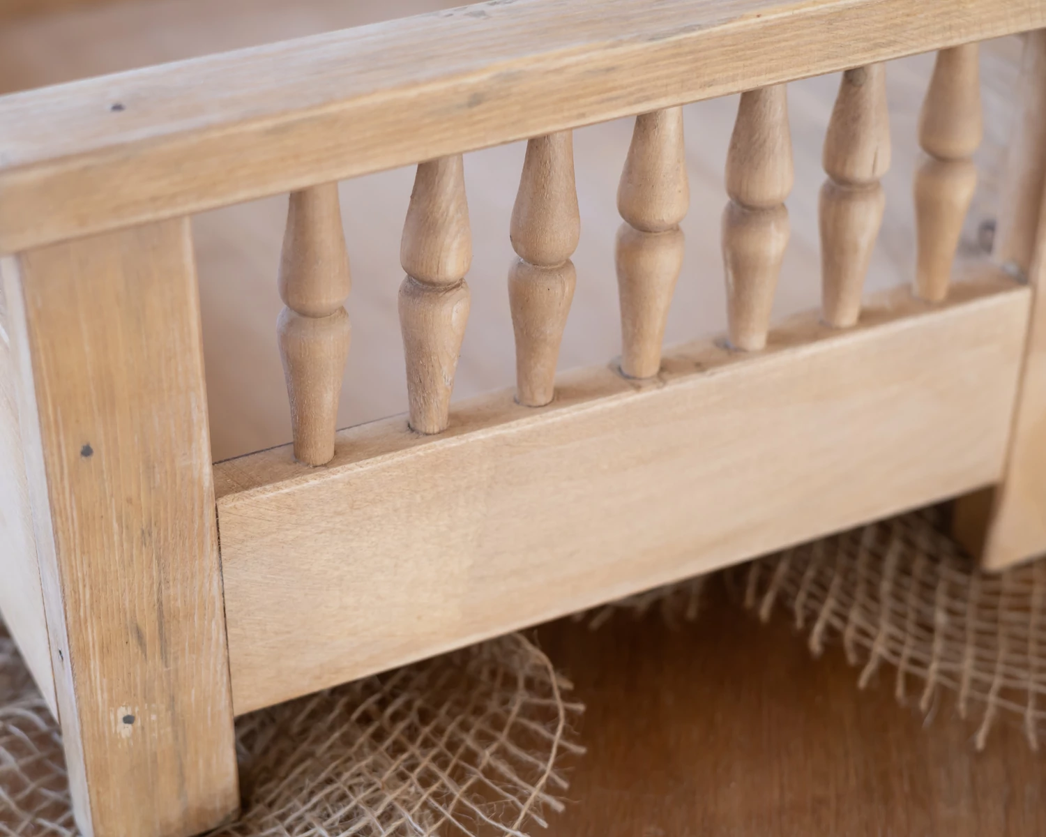 Natúr színű, antikolt fa ágy esztergált díszítéssel újszülött fotózáshoz