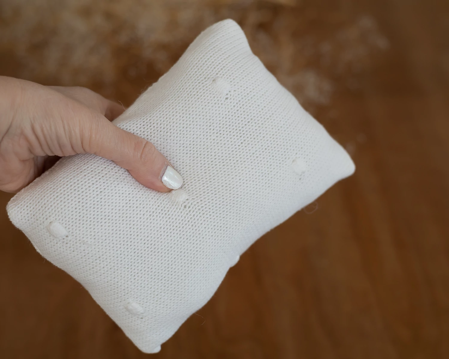 Törtfehér párna bogyós díszítéssel újszülött fotózáshoz