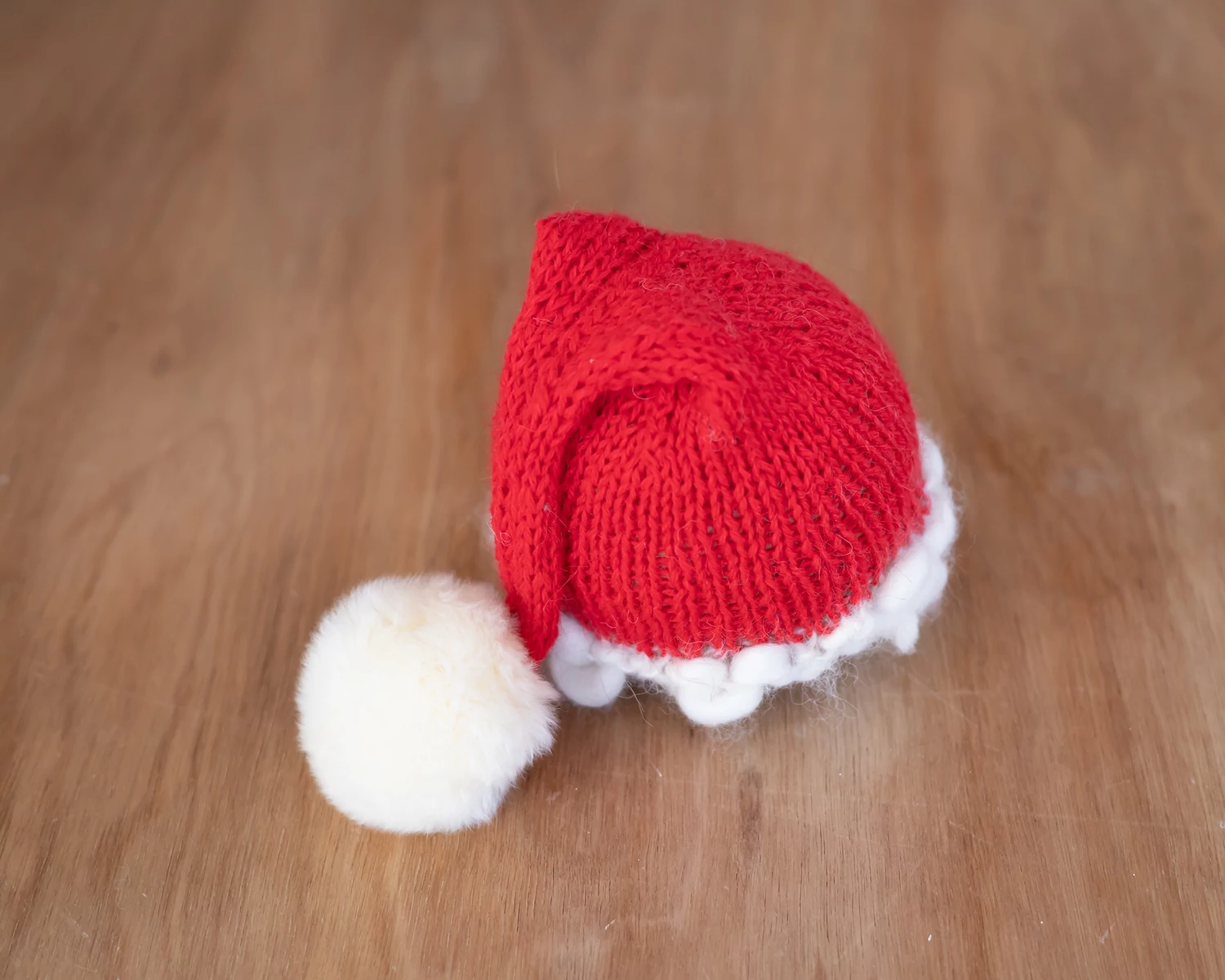 Piros- törtfehér szőrmebojtos kötött újszülött mikulás sapka
